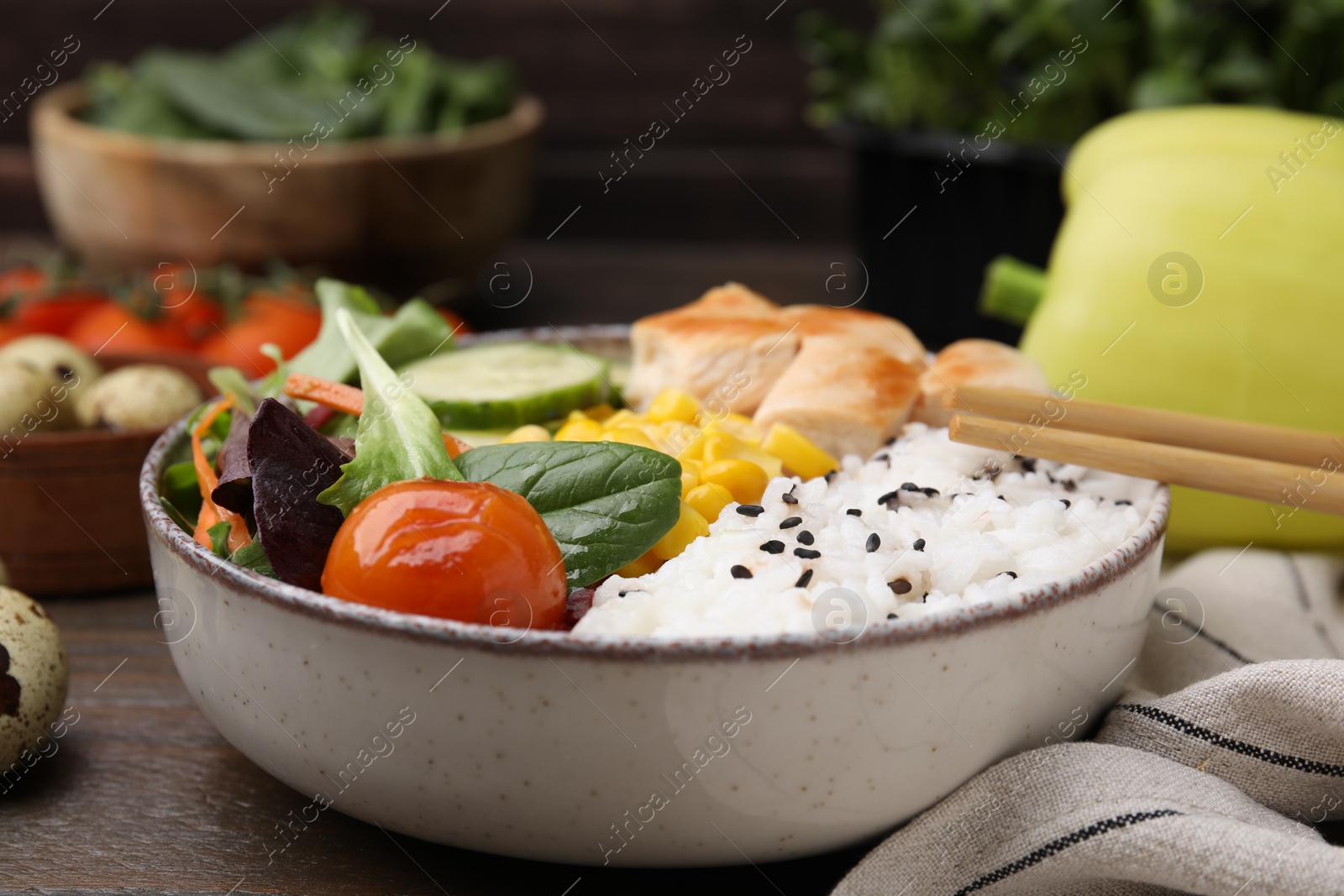 Photo of Delicious poke bowl with meat, rice, vegetables and greens on wooden table, closeup