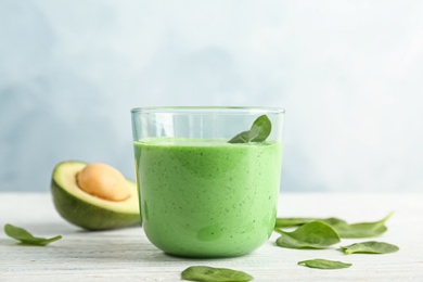 Photo of Glass with healthy detox smoothie and ingredients on table