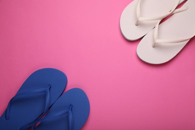 Photo of Stylish white and blue flip flops on pink background, flat lay. Space for text