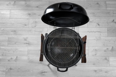 Photo of New modern barbecue grill on wooden floor