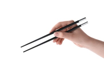 Photo of Woman holding pair of black chopsticks on white background, closeup