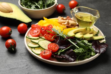 Balanced diet and vegetarian foods. Plate with different delicious products on black table, closeup