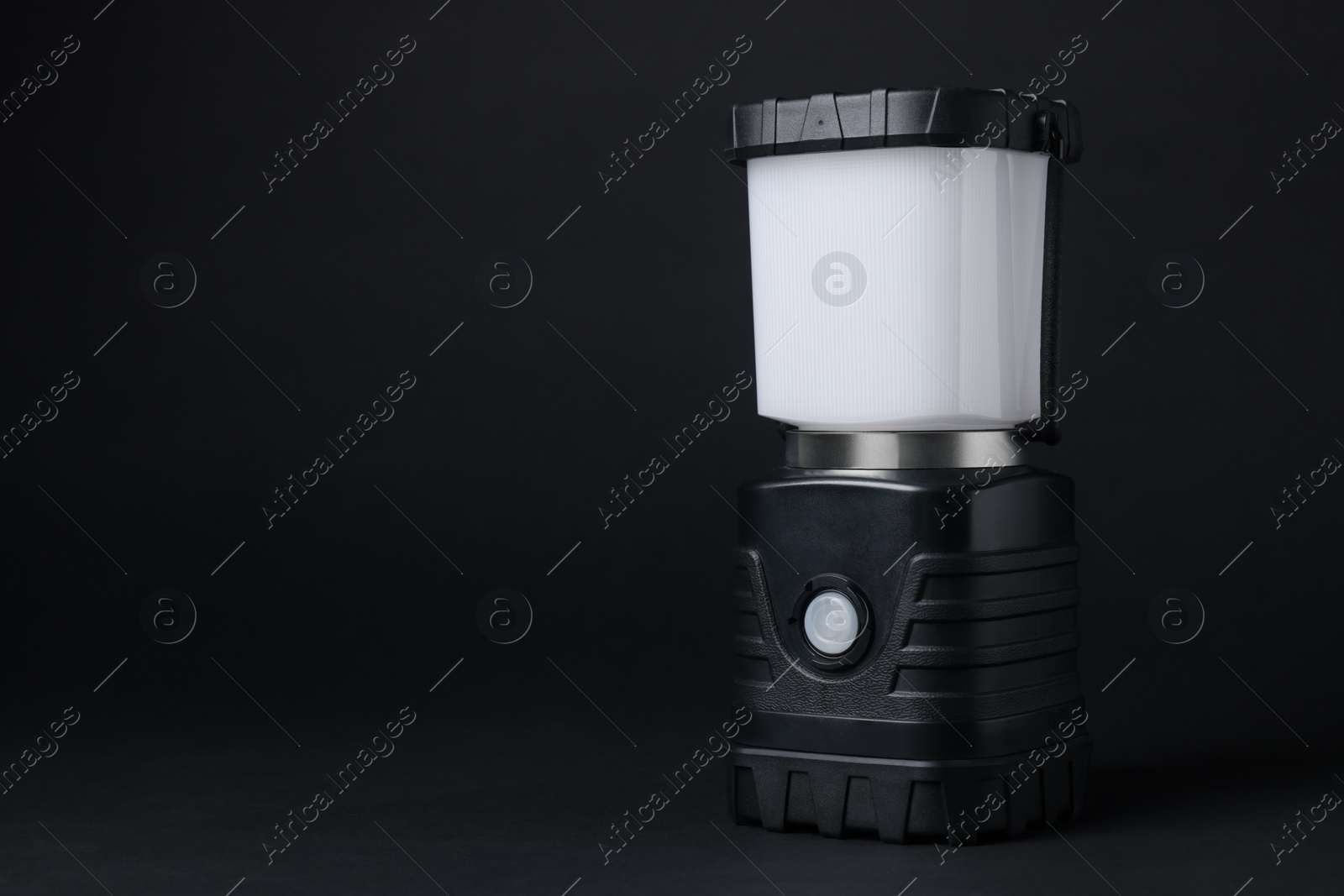 Photo of Camping lantern on black background, space for text. Military training equipment