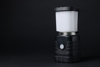Photo of Camping lantern on black background, space for text. Military training equipment