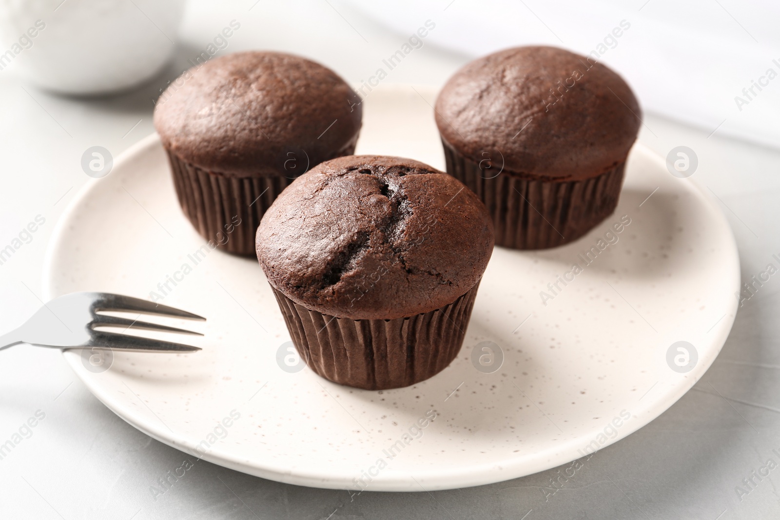 Photo of Delicious chocolate cupcakes on white table, closeup