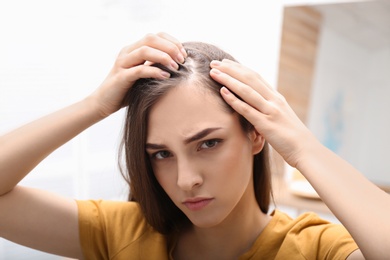 Photo of Young woman with hair loss problem indoors