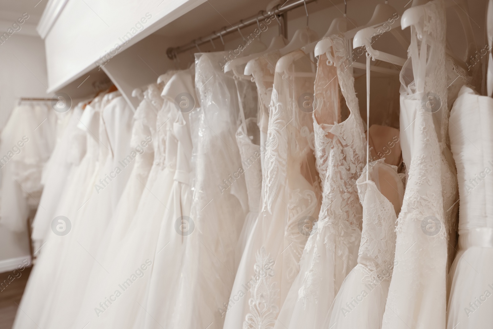 Photo of Different wedding dresses on hangers in boutique