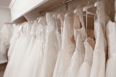 Different wedding dresses on hangers in boutique