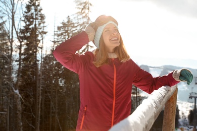 Happy young woman spending winter vacation in mountains