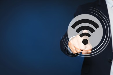 Image of Man touching Wi Fi symbol on digital screen against dark blue background, closeup