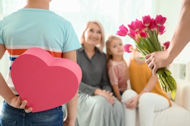 Photo of Little boy and his father congratulating their family at home