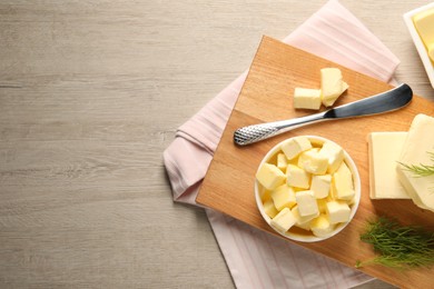 Photo of Tasty butter with dill and knife on wooden table, flat lay. Space for text