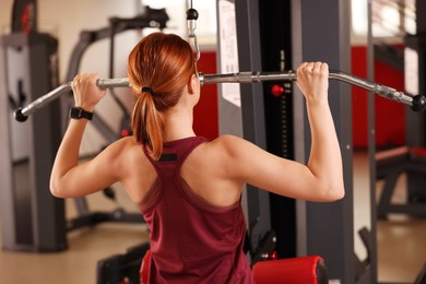 Young woman training in modern gym, back view