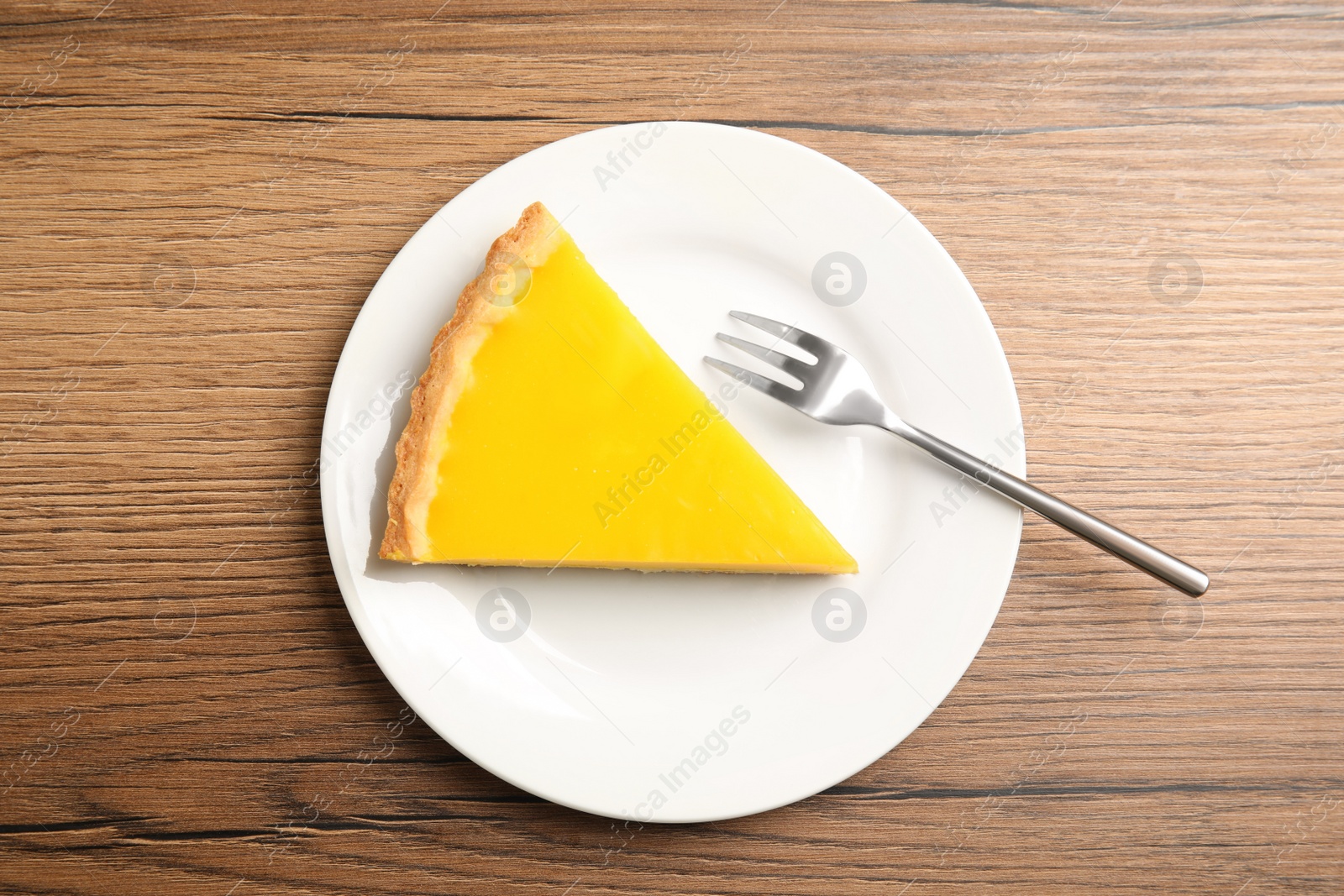 Photo of Delicious homemade lemon pie on wooden table, top view