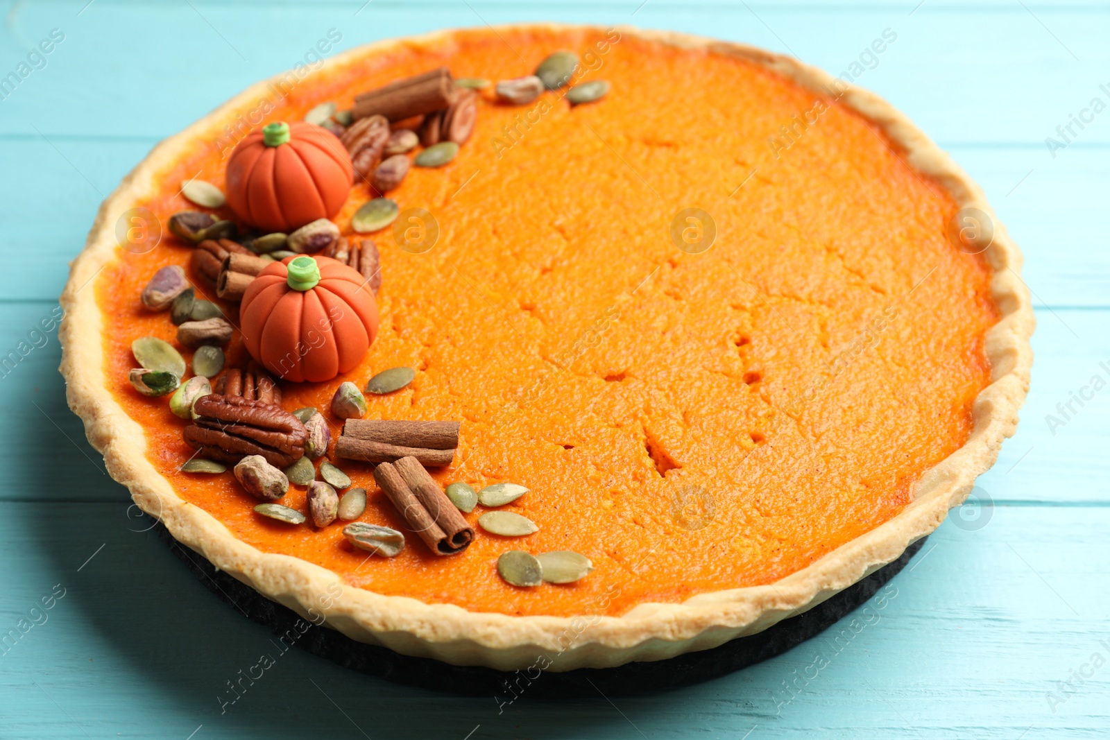 Photo of Delicious homemade pumpkin pie on light blue wooden table