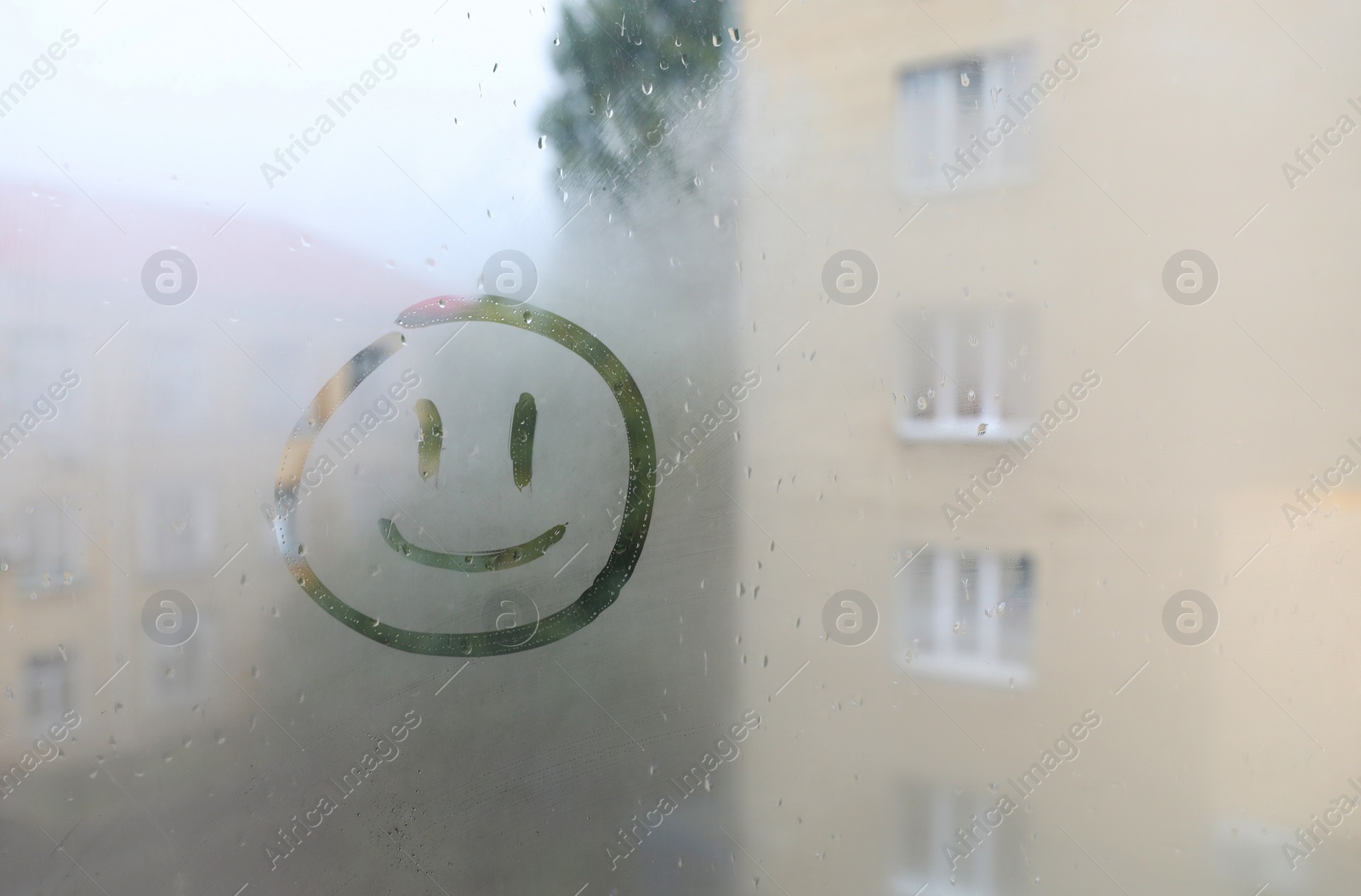 Photo of Funny face drawn on foggy window, space for text. Rainy weather