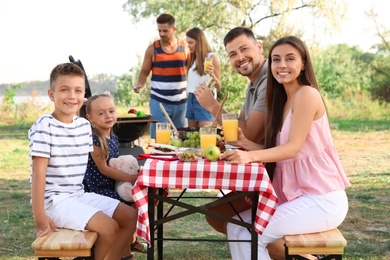 Happy families with little children having picnic in park