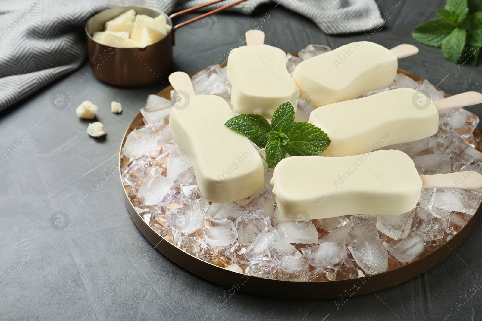 Photo of Glazed ice cream bars served with mint on grey table