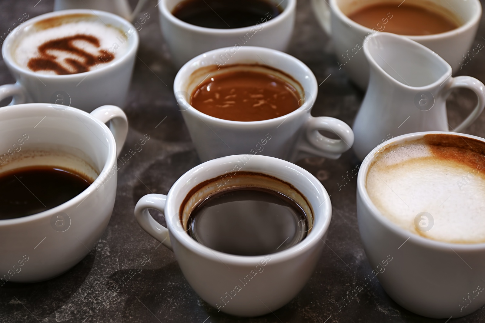 Photo of Cups of fresh aromatic coffee on grey background