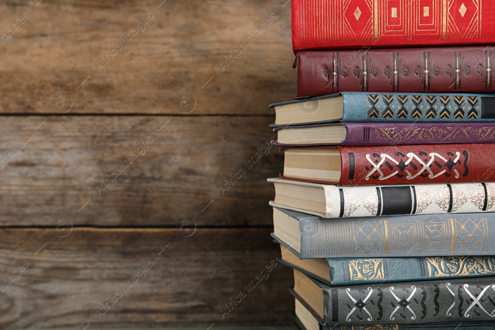 Photo of Stack of hardcover books on wooden background. Space for text