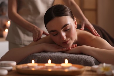 Photo of Spa therapy. Beautiful young woman lying on table during massage in salon