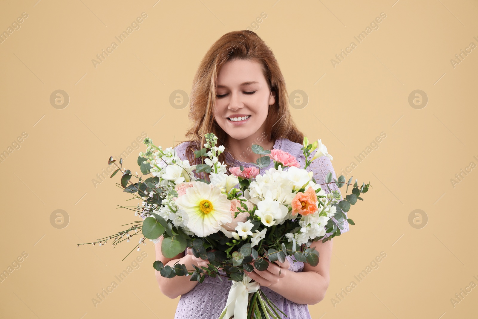 Photo of Beautiful woman with bouquet of flowers on beige background