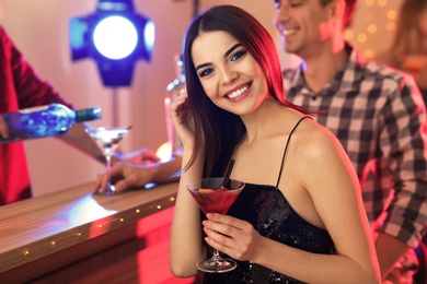 Photo of Beautiful young woman with glass of martini cocktail in bar