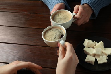 Photo of Women having coffee break at wooden table, closeup