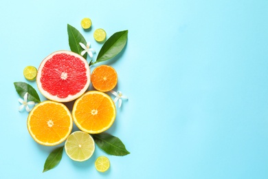 Photo of Flat lay composition with citrus fruits, leaves and flowers on color background. Space for text