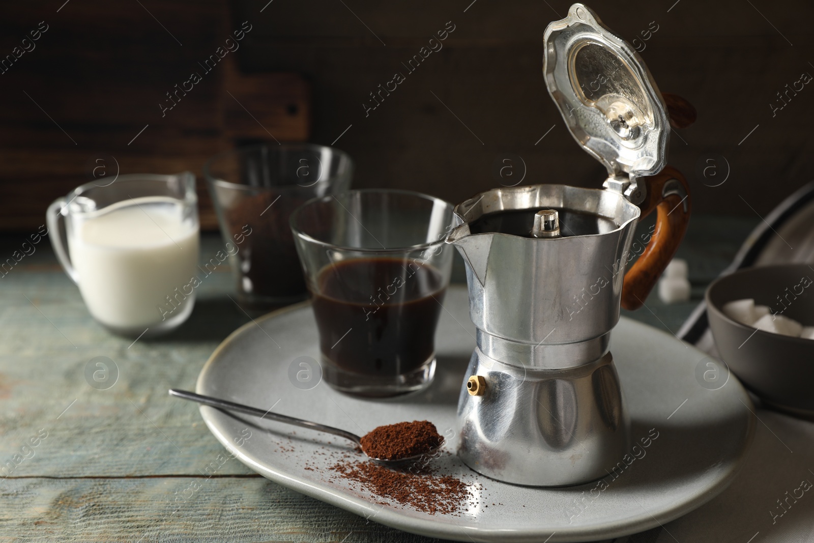 Photo of Brewed coffee in moka pot and glass on rustic wooden table