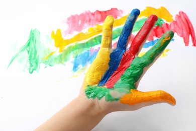 Child with painted palm on color background, closeup