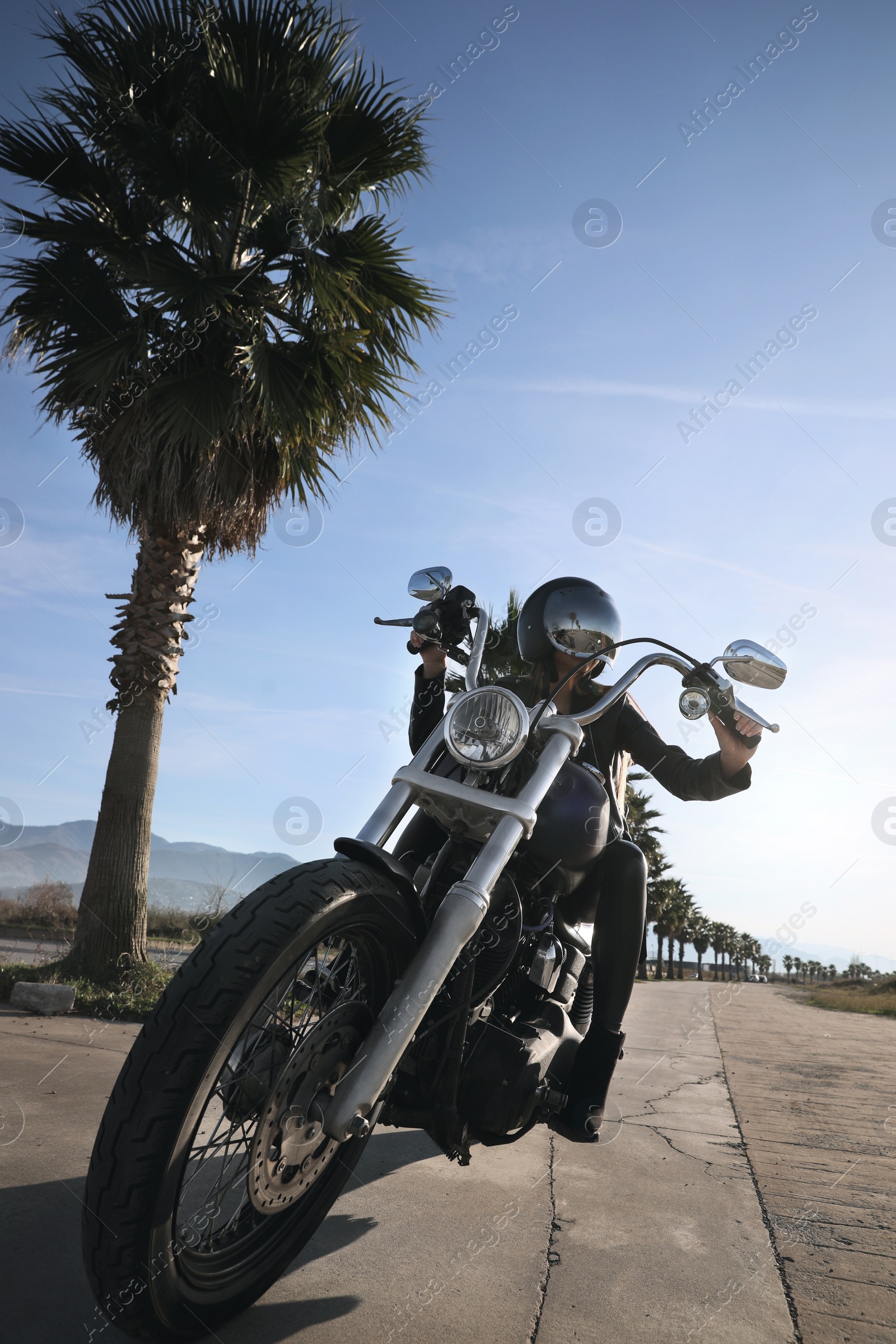 Photo of Woman in helmet sitting on motorcycle outdoors