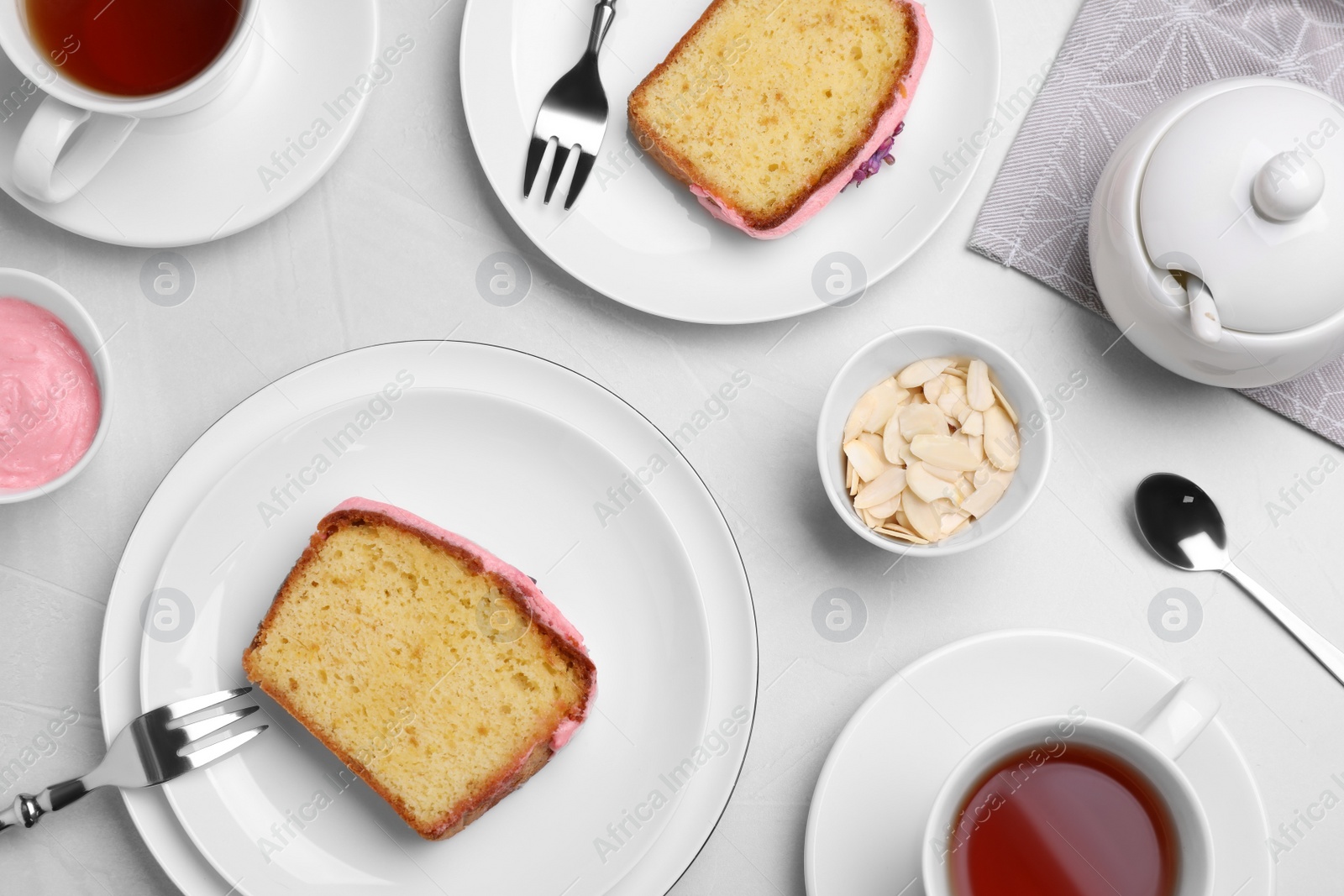Photo of Tasty breakfast with sweet cake and aromatic tea on white table, flat lay