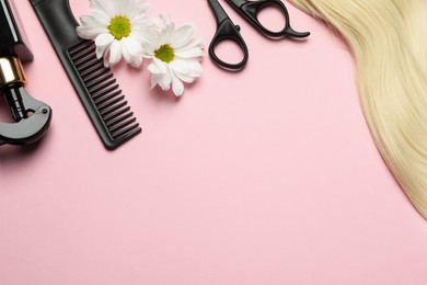 Flat lay composition with different hairdresser tools and flowers on pink background, space for text