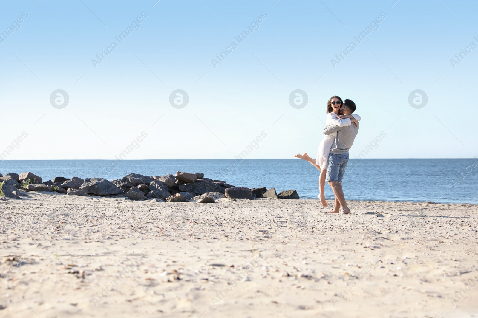 Photo of Happy young couple on beach near sea. Honeymoon trip