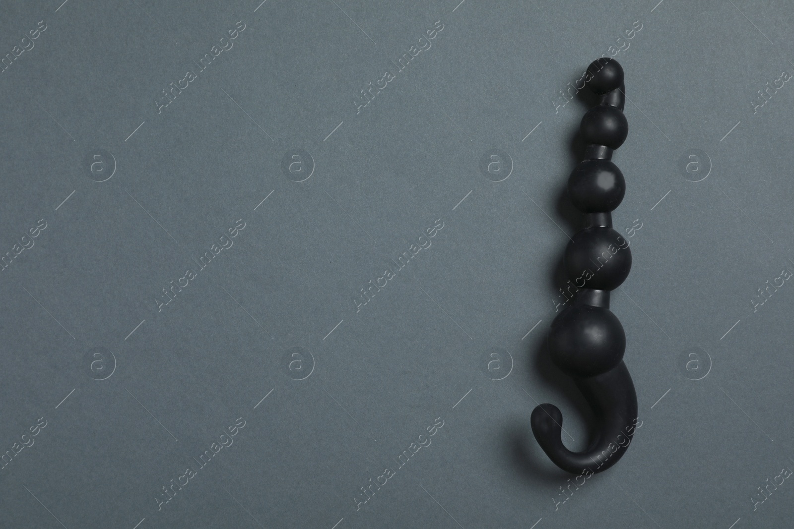 Photo of Black anal ball beads on dark background, top view with space for text. Sex toy