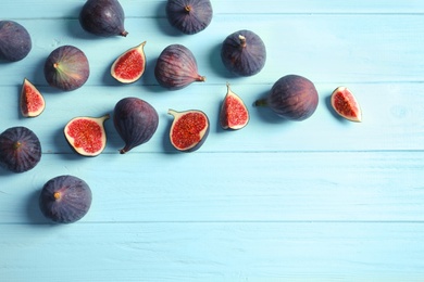 Photo of Fresh ripe figs on wooden background, top view. Space for text