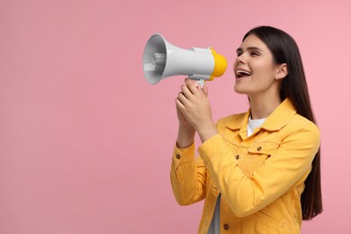 Special promotion. Emotional woman shouting in megaphone on pink background, space for text