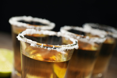 Mexican Tequila shots with salt on black background, closeup