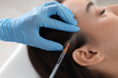 Trichologist giving injection to patient, closeup view