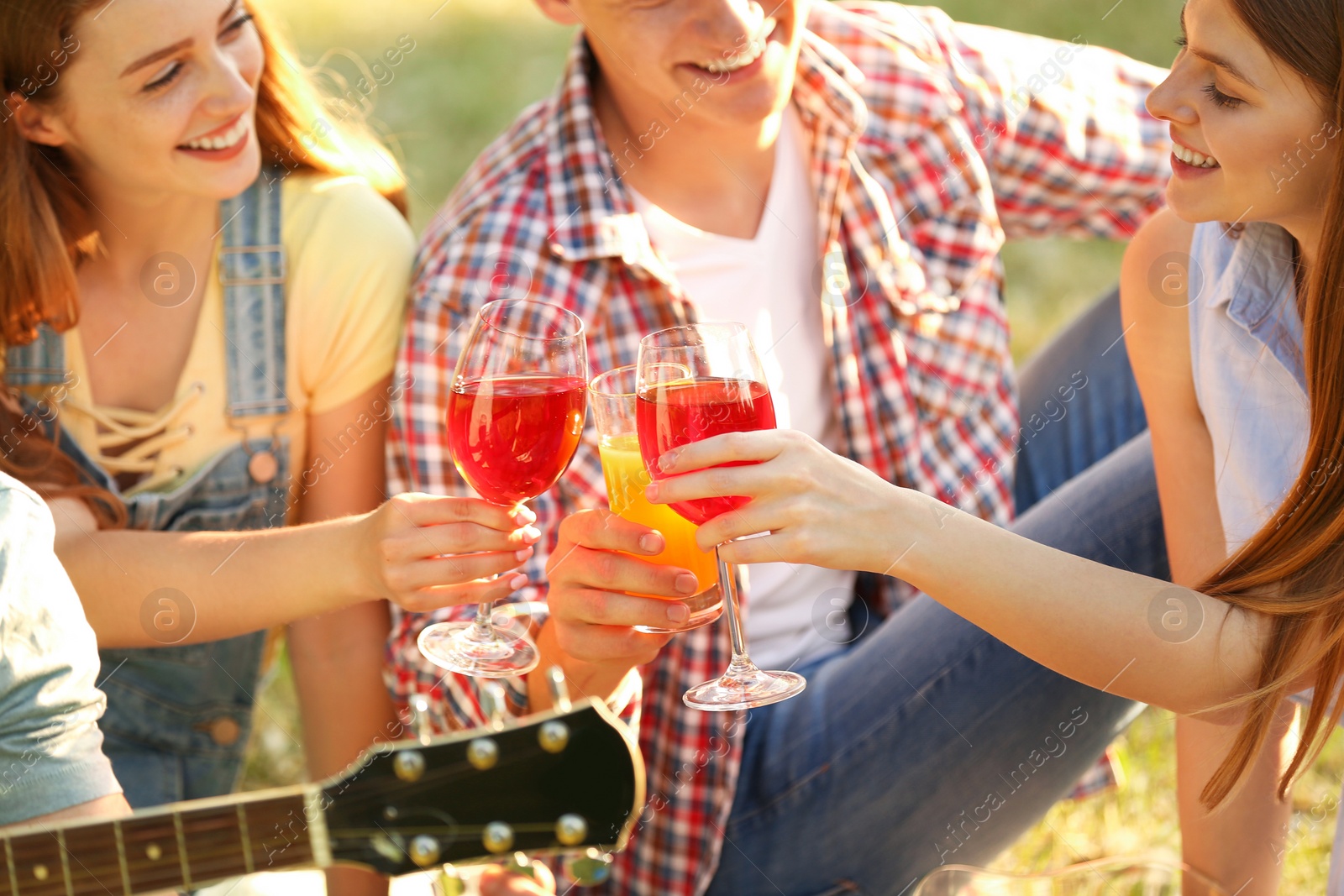 Photo of Young people enjoying picnic in park on summer day