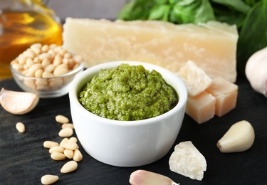 Photo of Bowl of pesto sauce and ingredients on table