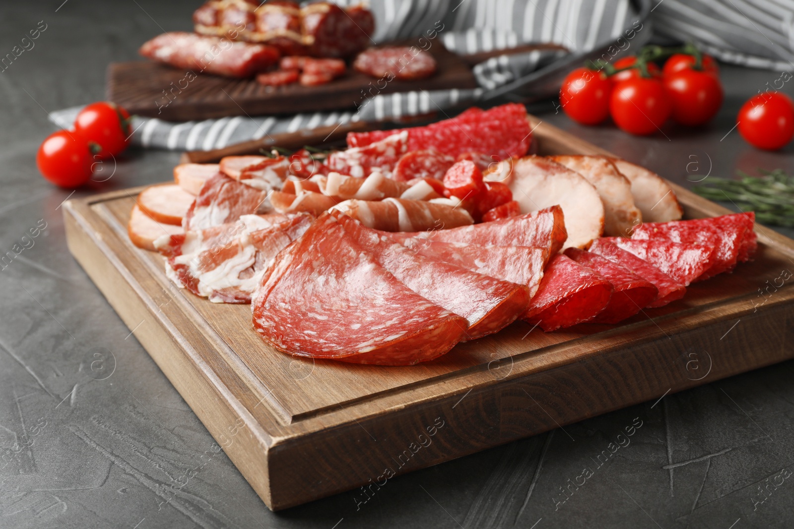 Photo of Cutting board with different sliced meat products served on table