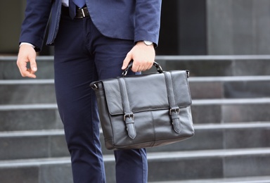 Businessman with black briefcase in hand outdoors