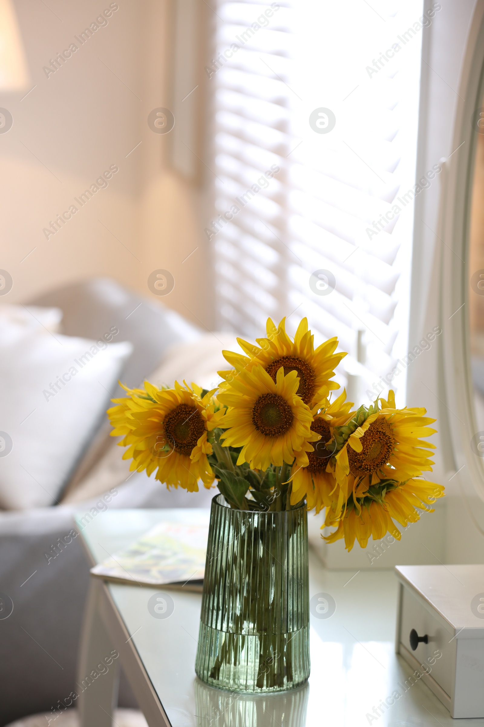 Photo of Beautiful bouquet of sunflowers in vase on white table indoors. Space for text