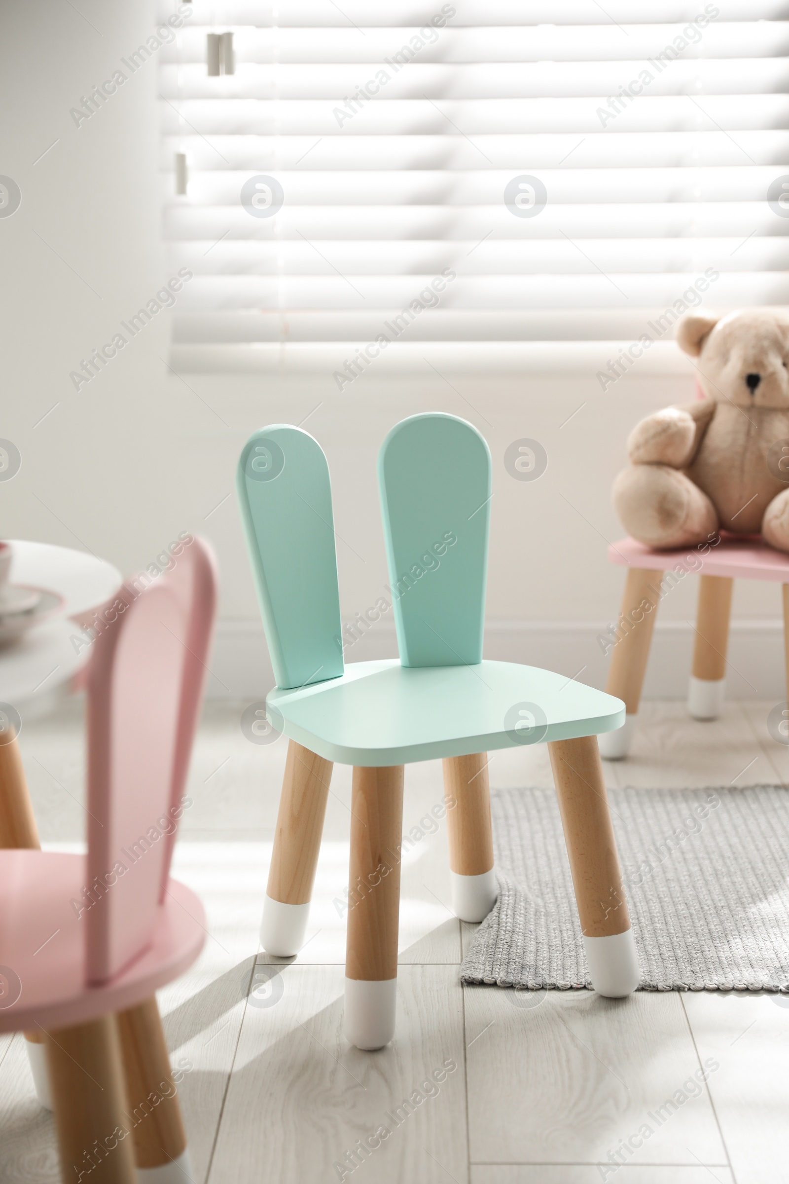 Photo of Cute little chair with bunny ears indoors. Children's room interior