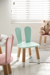 Photo of Cute little chair with bunny ears indoors. Children's room interior