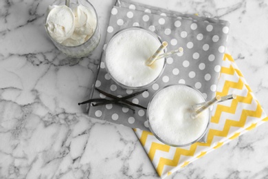 Glasses with milk shake and tasty vanilla ice cream on light background