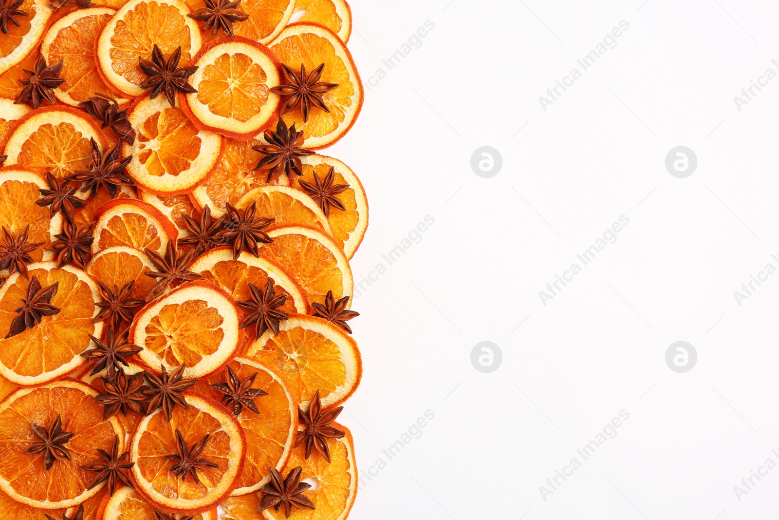 Photo of Dry orange slices and anise stars on white background, flat lay. Space for text