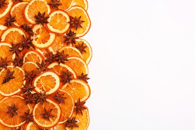 Dry orange slices and anise stars on white background, flat lay. Space for text